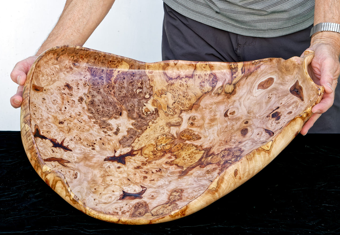 Fancy and irregular 22.5” long maple platter-like bowl sculpted from spalted maple. It has twisted and figured burl patterns, bird's-eye patterns, and rich colors of tan, brown, and gold with a hint of red, 215-A
