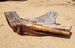 Raw old dead and dry Utah juniper wood with no bark as found and to be used for a natural wood sculpture, sitting on dirt 