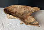 Front top view of figured tan and brown maple wooden irregular bowl, smooth and soft with beautiful grain patterns, intriguing clear epoxy-filled fine cracks and rich natural colors (no stains or artificial colors added).  It is displayed on a light colored background (with a black wall).  It measures 6 tall x 23 x 16’’, 5.8 lbs. 