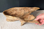 Front view of figured tan and brown maple wooden irregular bowl, smooth and soft with beautiful grain patterns, intriguing clear epoxy-filled fine cracks and rich natural colors (no stains or artificial colors added).  It is being held by a hand, on a light colored background (with a black wall).  It measures 6 tall x 23 x 16’’, 5.8 lbs. 