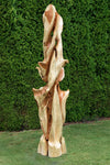 Possible rear view of a tall and twisted wood sculpture (shown in front of a green tree hedge), rich looking one-of-a-kind 7' 3" tall by 22.5" x 22'' natural western juniper floor sculpture that emphasizes the tree's natural form and beauty.  It has some live edge design and is a combination of smooth surfaces with beautiful grain patterns and and a few slightly rough areas.  Some preserved insect holes show its past visitors.
