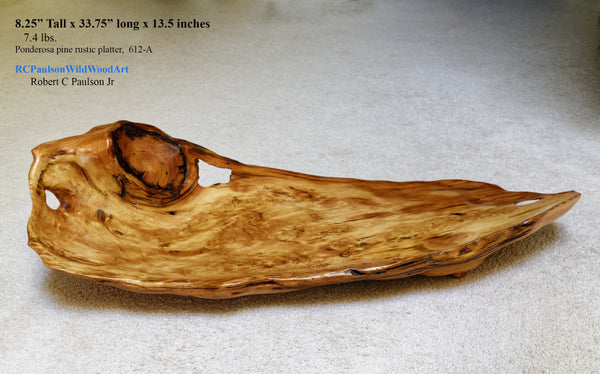 Top and front view of a 34 inch long natural wood serving platter with a rustic, irregular shape and prominent grain, displayed on a neutral gray background with product specifications printed in the upper left corner.  Front and top view of a one-of-a-kind Ponderosa pine charcuterie board, live edge platter that is both smooth and rough with live edge features and beautiful grain patterns.  It measures 8.25 tall x 33.75 inches long x 13.5'', 7.8 lbs. and is shown here lying on a beige carpet. 