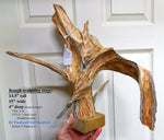 Wooden sculpture held by a hand with text detailing its dimensions and weight.