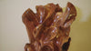 Close up video of the top of an exotic wood sculpture 32.5 inch tall, freeform.  One-of-a-kind brown and golden orange, black walnut floor sculpture with an abstract interwoven design with some parts somewhat resembling wild flowers or leaves.  It has beautiful grain patterns and measures 32.5 x 17.5 x 17'', 36.8 lbs.